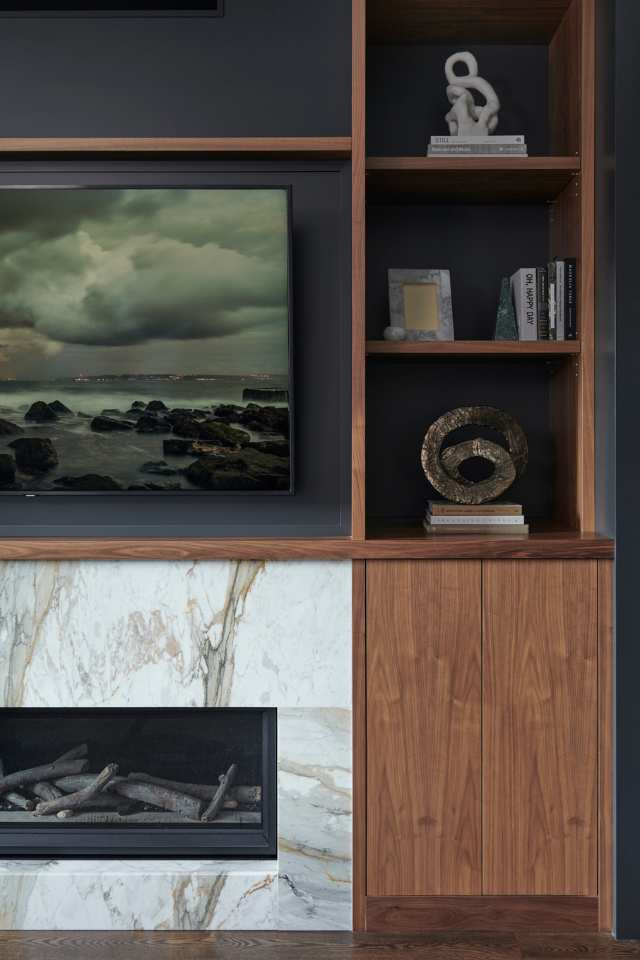 quiet luxury living room with marble fireplace and classic wood shelving